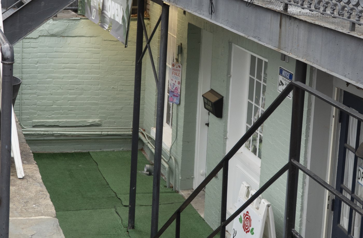 Looking down the iron stairs off M Street to the mint-green brick entrance of Georgetown Dispensary